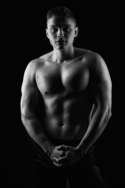 strong athletic man on black background - 写真・画像