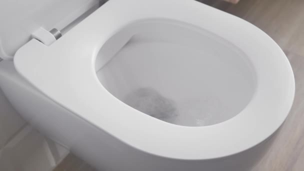 A full flush in the toilet with a large flow of fresh water into the sewer. Wasteful use of outdated plumbing, plumbing and sewerage in the bathroom. - Footage, Video