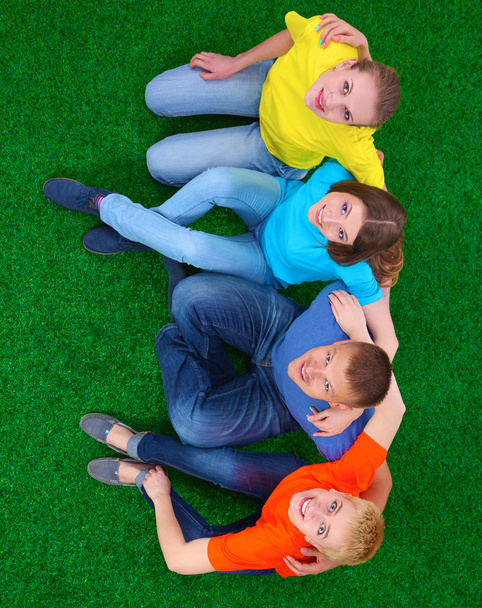 Groupe de jeunes couchés sur l'herbe verte
 - Photo, image