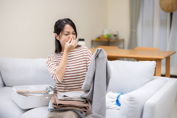 Žena v domácnosti trpí špatným čicháním oblečení doma - Fotografie, Obrázek