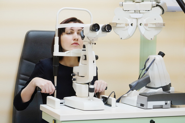 Woman looking into eye test machine - Foto, Bild