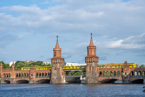 Η όμορφη Oberbaumbruecke στο Βερολίνο με ένα κίτρινο τρένο του μετρό - Φωτογραφία, εικόνα