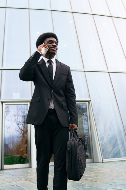 Jovem africano de terno lida com uma chamada de negócios com postura. - Foto, Imagem