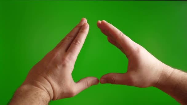 人間の手は緑の背景に心臓のジェスチャーを示します. - 映像、動画