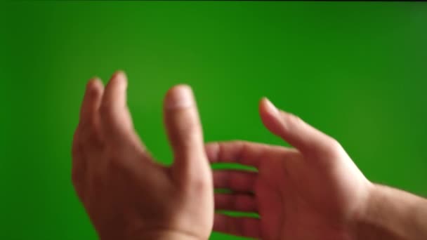 Un hombre muestra un gesto de apretón de manos sobre un fondo verde. - Imágenes, Vídeo