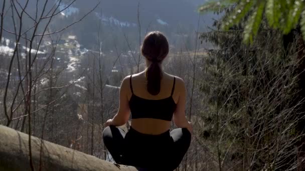 Asszony ül az ászana a gyönyörű táj havas hegység a háttérben - Felvétel, videó