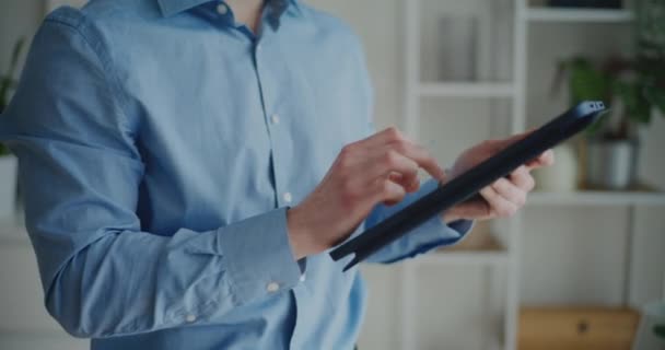 Midsection του νεαρού επιχειρηματία χρησιμοποιώντας ψηφιακή ταμπλέτα με γραφίδα, ενώ στέκεται σε εταιρικό χώρο εργασίας - Πλάνα, βίντεο