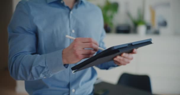Magabiztos jóképű fiatal férfi szakmai írás stratégia digitális tabletta stylus, miközben áll a vállalati munkaterület - Felvétel, videó