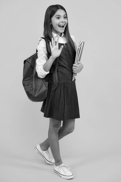 School girl teenager child with book and copybook. Teenager schoolgirl student with backpack, isolated background. Learning and knowledge education concept - 写真・画像