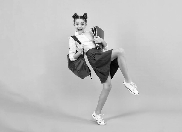 Amazed teenager. School teenager child girl with book and copybook. Teenager student, isolated background. Learning and knowledge. Excited teen girl. Crazy jump and run, jumping kids - Fotografie, Obrázek
