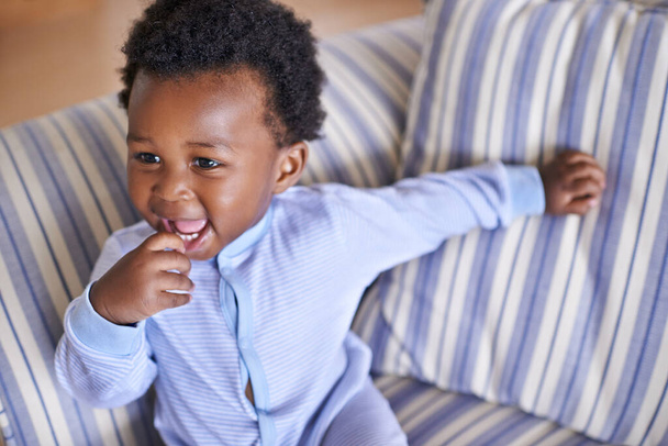 Bebé, sonrisa o sofá como juego, diversión o juego para el ocio y el juego, crecimiento como relajarse, aprender o humor. Emocionado, niño negro o risa como confianza curiosa para la coordinación o el desarrollo de habilidades motoras. - Foto, Imagen