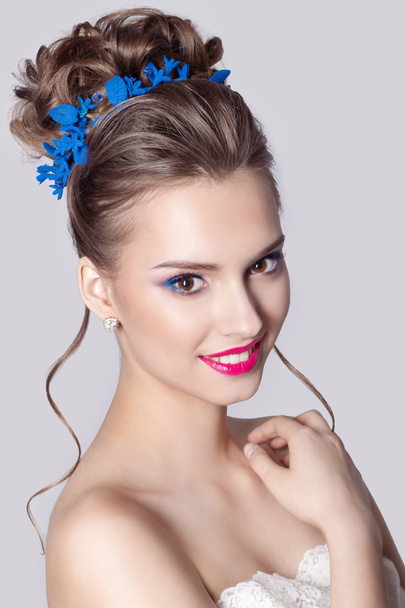 Fashion portrait of a beautiful attractive girl with a gentle elegant evening wedding hairstyles high and bright make-up , with flowers in their hair and large earrings - 写真・画像