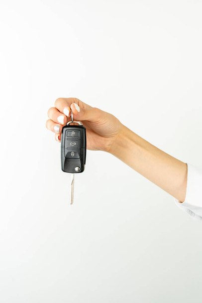 Jeune tenant dans la main système de clé de voiture sans clé isolé sur fond de couleur blanche studio. Concept de style de vie - Photo, image