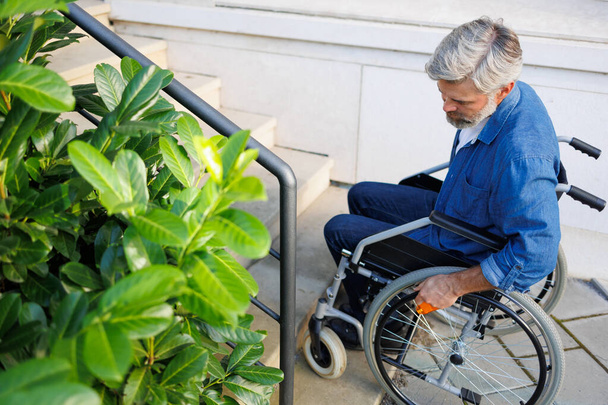 Мужественный восхождение: человек в инвалидных колясках Снасти лестницы - Фото, изображение