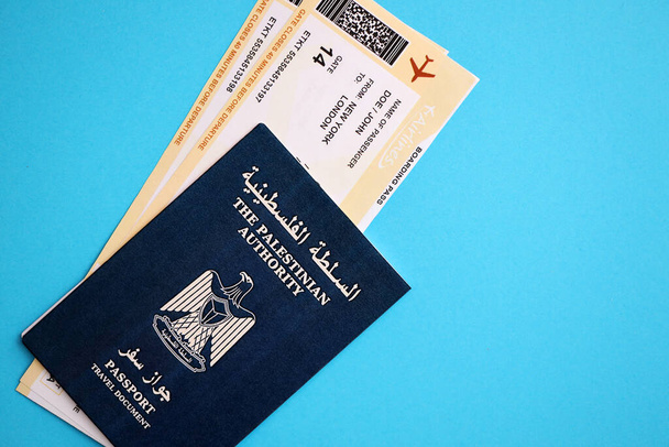 Blue Palestinian Authority διαβατήριο με αεροπορικά εισιτήρια σε μπλε φόντο από κοντά. Τουρισμός και ταξιδιωτική έννοια - Φωτογραφία, εικόνα