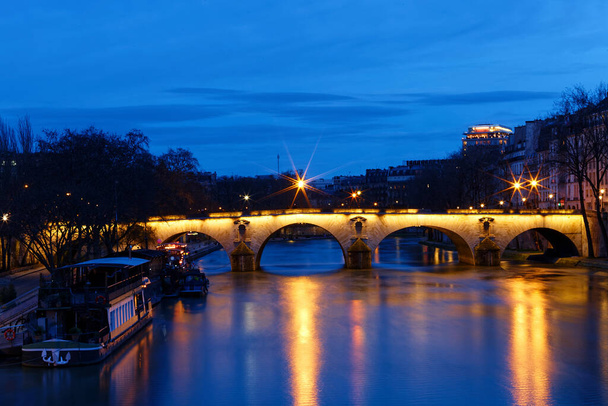 Панорамний вид на міст Понте-Марія над річкою Сена вночі, Париж, Франція. Це один з найстаріших мостів Парижа, який датується XVII століттям.. - Фото, зображення