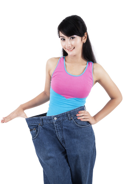 Slim woman with her old jeans - Фото, зображення