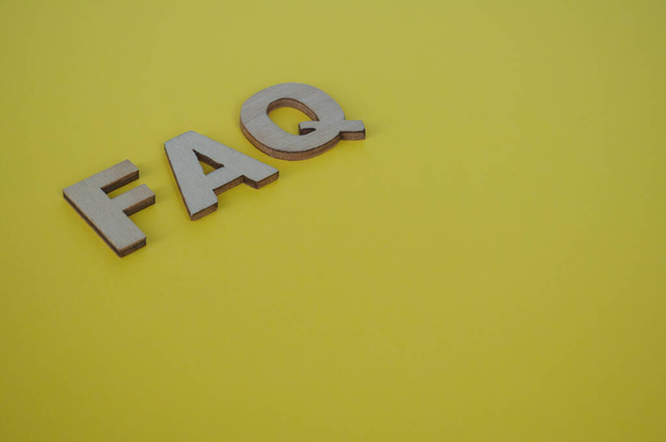 FAQ wooden letters on yellow background. Question and Answer concept. - Photo, Image