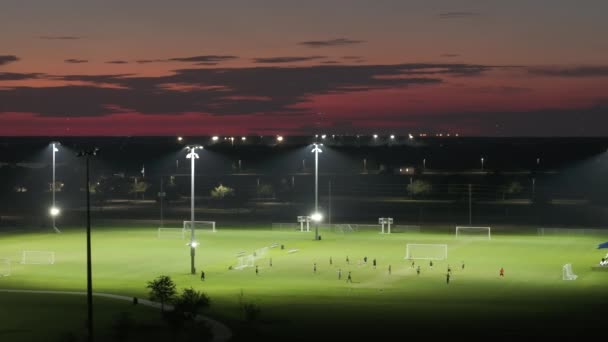 Entrenamiento de deportistas en el partido de fútbol en el estadio de fútbol iluminado en el parque deportivo público en North Port, Florida. - Metraje, vídeo