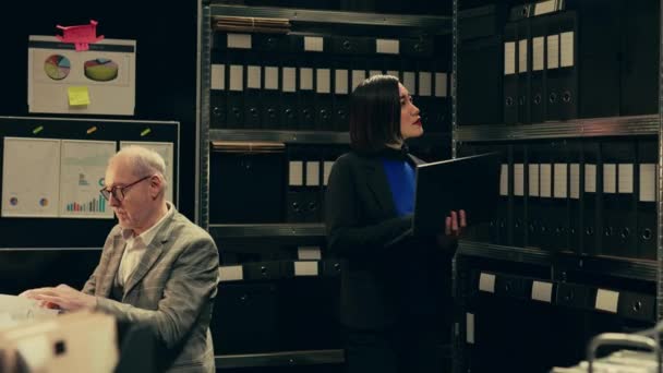Private investigator organizes archived files for easy access, searching for old file cases to cross reference data. Law enforcement agent looking for classified folders in archive room. Camera B. - Footage, Video