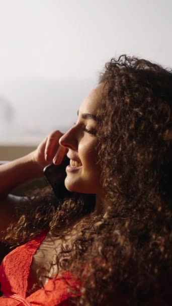Neuvěřitelná latina žena mluví do telefonu dívá ven - FHD Vertikální video - Záběry, video