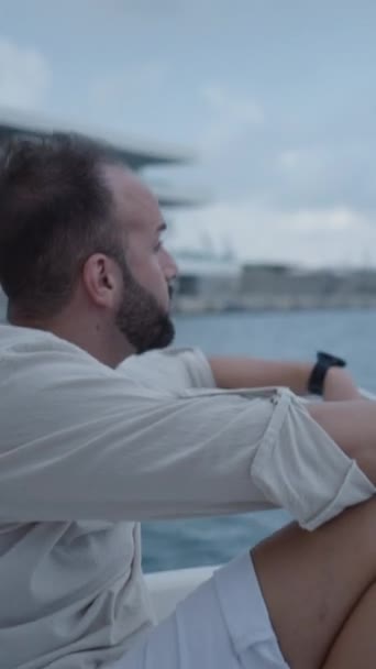 Egy fiú ül nyugodtan egy hajón, körülnéz - függőleges FHD Luxus életmód - Felvétel, videó