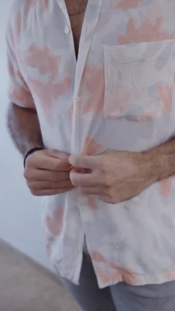 Menino latino com barba ajustando uma camisa estampada - FHD Vídeo vertical - Filmagem, Vídeo