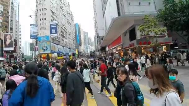 Hong Kong - 2023. december 2.: Emberek átkelnek egy forgalmas úton Causeway Bay-ben - Felvétel, videó