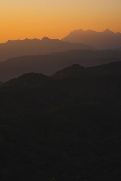 φύση ταξιδεύει με πορτοκαλί ουρανό και στρώμα του βουνού με φόντο την ανατολή του ηλίου - Φωτογραφία, εικόνα