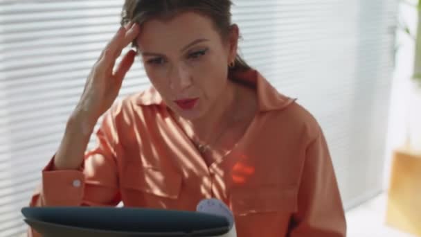 Inclinación hacia arriba tiro de mujer estresada empleado mirando informe de negocios trabajando en la oficina - Imágenes, Vídeo