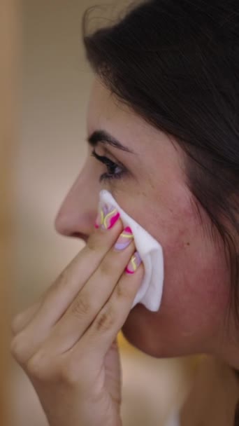 Dziewczyna dotykająca twarzy gazikiem po zabiegu seroterapii - FHD Vertical video - Materiał filmowy, wideo