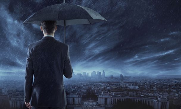 Elegant businessman staring at the city in the night - Photo, image