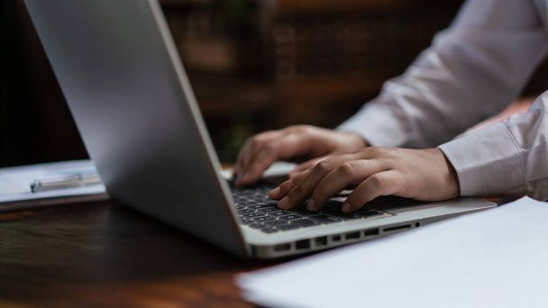 Mãos de mulher de negócios que digita dados no teclado do computador portátil enquanto trabalha sobre o financeiro do negócio. - Foto, Imagem