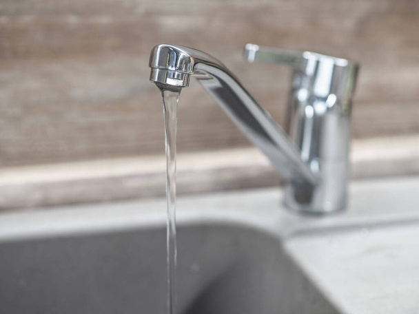 Faucet with water on the background of a wooden wall - Photo, Image