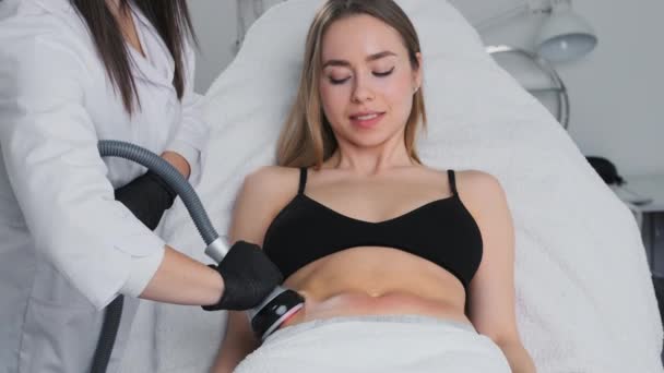 Mujer recibiendo ultrasonido cavitación anti celulitis procedimiento en un salón de belleza. Concepto de cosmetología de hardware - Imágenes, Vídeo