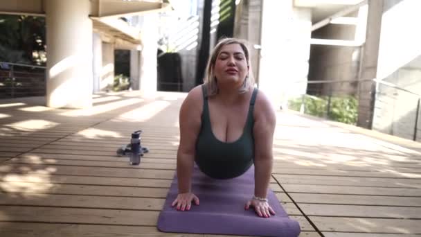 Inspiráló jógagyakorlat, ahol egy nő szakértő pózt tart a lábtörlőjén a szabadban.. - Felvétel, videó
