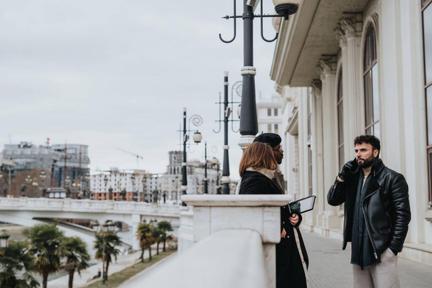 Mies ja nainen keskustelevat sillalla ja esittelevät urbaania katumuotia kaupunkimaisemaa vasten pilvessä.. - Valokuva, kuva