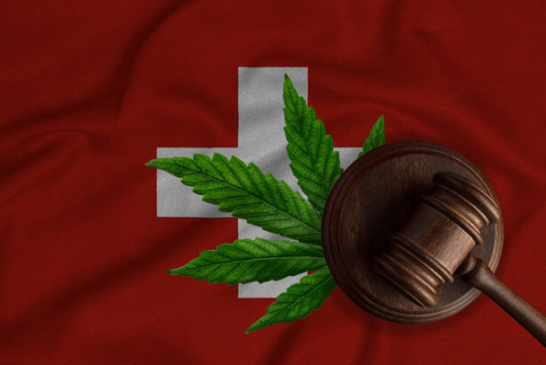 Tuomarin nuija ja kannabiksen lehti Sveitsin lipun alla. Käsite laillistaminen marihuanan Sveitsissä. - Valokuva, kuva