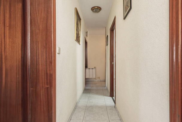 Distributeur gangen van een huis met lichte stenen vloeren en verschillende sapelly houten deuren - Foto, afbeelding