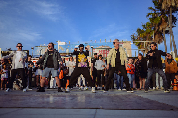 9 Mart 2024, Los Angeles, ABD. Dansçılar ve sanatçılar Venedik sahilinde turist kalabalığında performans sergilediler. Halka açık bir yerde sokak yetenekleri gösterisi. Seyirciler heyecanlanıyor ve eğleniyor. - Fotoğraf, Görsel