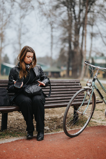 Selbstbewusste und attraktive junge Frau im eleganten Business-Outfit macht mit ihrem Fahrrad eine Pause im Freien - Foto, Bild