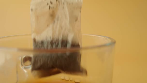 φλιτζάνι τσάι με τσάι τσάντα σε κοντινό πλάνο ξύλινο τραπέζι - Πλάνα, βίντεο