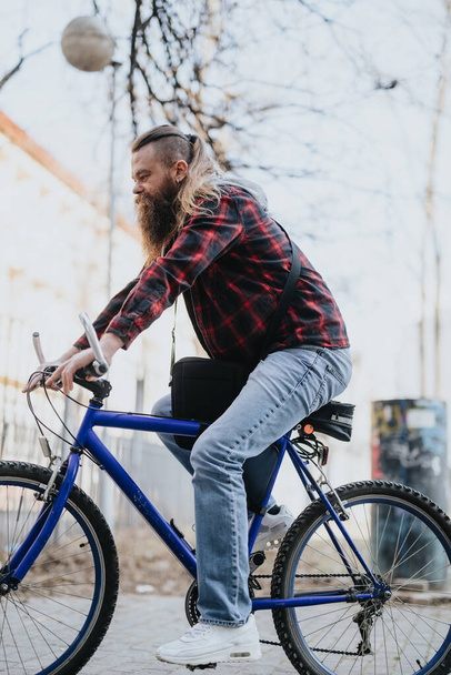 Nowoczesny przedsiębiorca na niebieskim rowerze w środowisku miejskim, prezentujący przyjazne dla środowiska dojazdy do pracy i pracę zdalną. - Zdjęcie, obraz