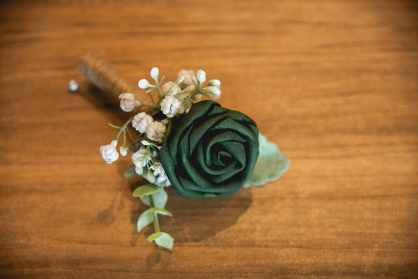 Un boutonnire es una decoración floral, típicamente una sola flor o un solo palo, usado en la solapa de un esmoquin o chaqueta de traje.. - Foto, imagen