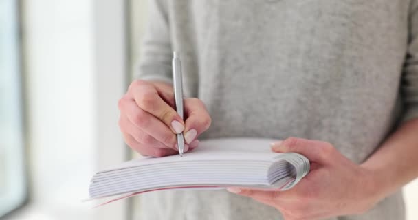 A nő szorgalmasan írja a fontos részleteket a jegyzetfüzetbe. Nő írja gondolatok és gondolatok óvatosan személyes napló lassított felvétel - Felvétel, videó