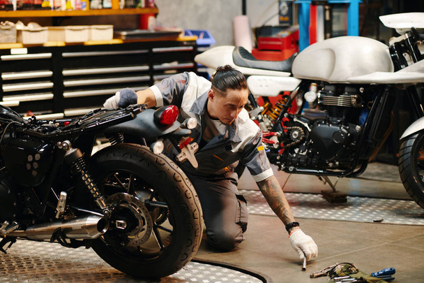 Szerelői munka a garázsban, motorkerékpár alkatrészeinek cseréje - Fotó, kép