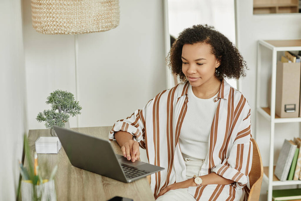 Портрет черной молодой женщины с помощью ноутбука на рабочем месте домашнего офиса в минимальном белом интерьере, копировальное пространство - Фото, изображение