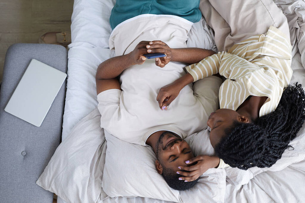 Afrika kökenli Amerikalı çiftin boş günlerinde yatak odasında dinlenmesi. - Fotoğraf, Görsel
