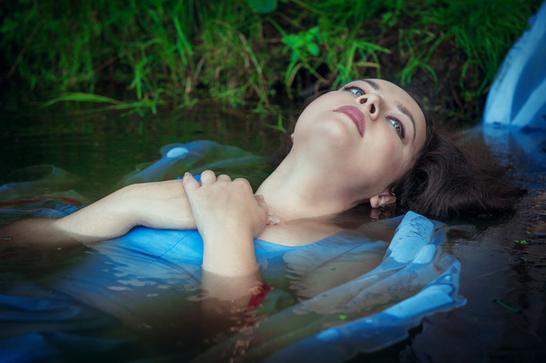 水で横になっている青いドレスの若い溺死美人  - 写真・画像