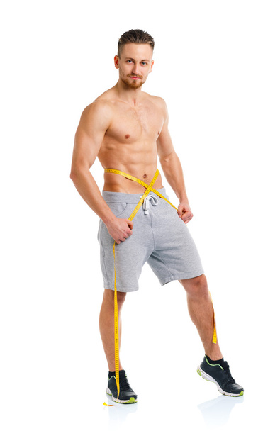 Athletic man with measuring tape on the white - Foto, Imagen